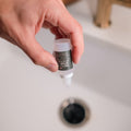 Applying Fruit Fly Defense Sink Drops to kitchen sink drain — part of the Combo Pack two-layer fruit fly defense system